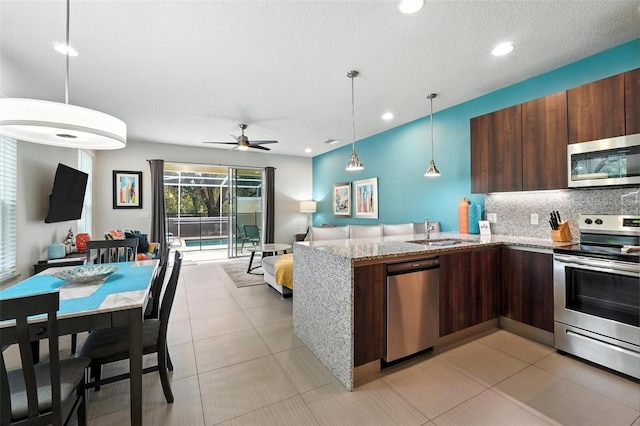 1530 Retreat Cir, Clermont, FL 34714 - kitchen featuring stainless steel appliances, ceiling fan, a peninsula, modern cabinets, and backsplash