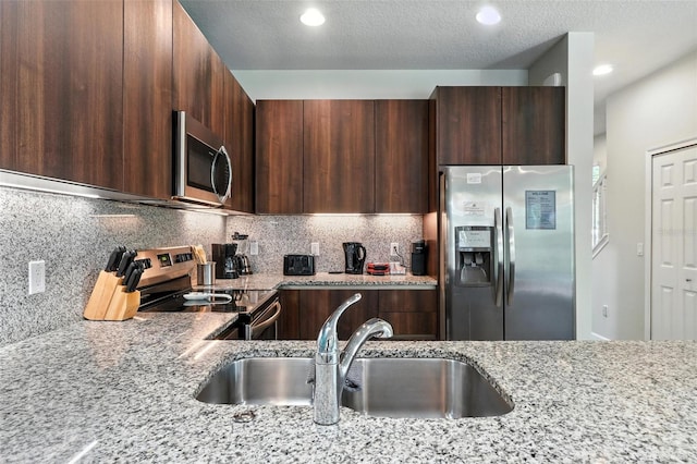 1530 Retreat Cir, Clermont, FL 34714 - kitchen with appliances with stainless steel finishes, modern cabinets, light stone counters, decorative backsplash, and dark brown cabinetry