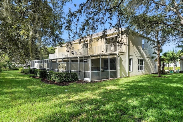 1530 Retreat Cir, Clermont, FL 34714 - rear view of property featuring a balcony, a sunroom, a lawn, and stucco siding