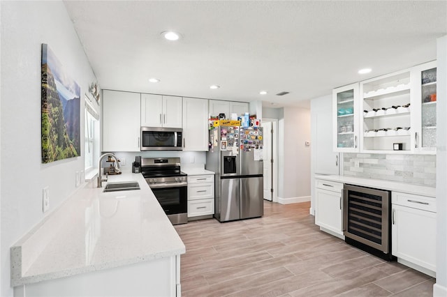 2926 Carriage Dr, South Daytona, FL 32119 - kitchen with appliances with stainless steel finishes, wine cooler, white cabinetry, and recessed lighting