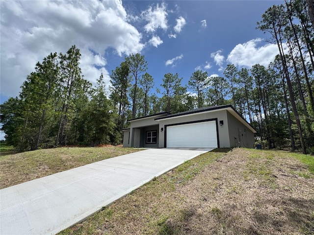 7687 N Quibble Ave, Dunnellon, FL 34434 - view of front of property featuring stucco siding, an attached garage, and concrete driveway