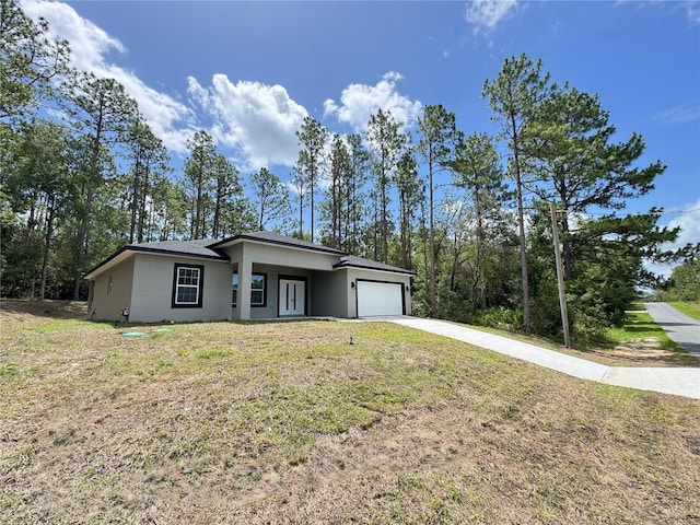 7687 N Quibble Ave, Dunnellon, FL 34434 - view of front of house with driveway, an attached garage, a front yard, and stucco siding