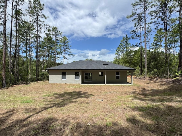 7687 N Quibble Ave, Dunnellon, FL 34434 - rear view of house featuring a patio area, stucco siding, and a lawn