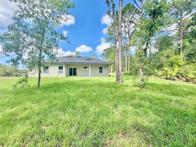 8051 N Pinkinz Way, Citrus Springs, FL 34433 - rear view of property with stucco siding and a lawn