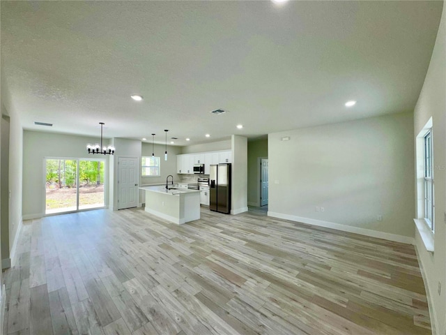 8051 N Pinkinz Way, Citrus Springs, FL 34433 - unfurnished living room featuring a chandelier, recessed lighting, light wood-style floors, and a textured ceiling