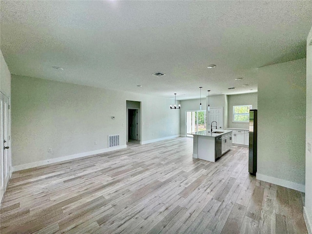 8051 N Pinkinz Way, Citrus Springs, FL 34433 - unfurnished living room featuring a textured ceiling, light wood-type flooring, and a chandelier