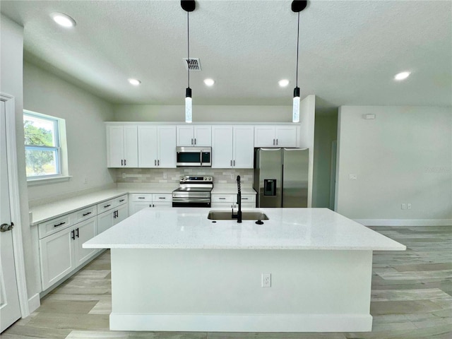 8051 N Pinkinz Way, Citrus Springs, FL 34433 - kitchen with stainless steel appliances, light wood-style flooring, recessed lighting, a kitchen island with sink, and white cabinetry