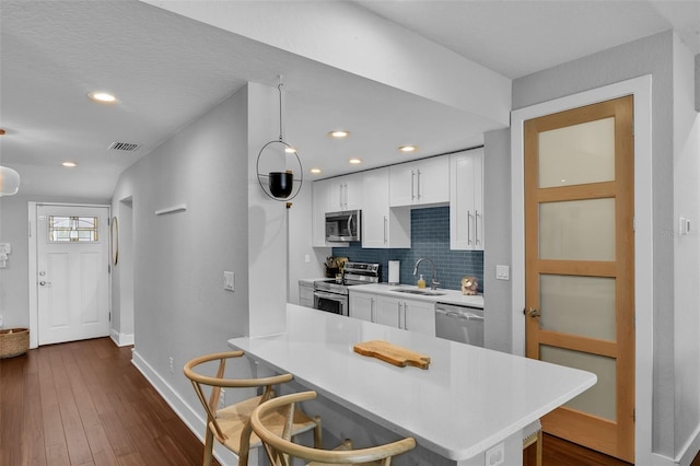 1322 N Bumby Ave, Orlando, FL 32803 - kitchen featuring stainless steel appliances, light countertops, white cabinetry, backsplash, and recessed lighting