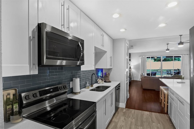 1322 N Bumby Ave, Orlando, FL 32803 - kitchen featuring stainless steel appliances, white cabinetry, light countertops, a ceiling fan, and recessed lighting