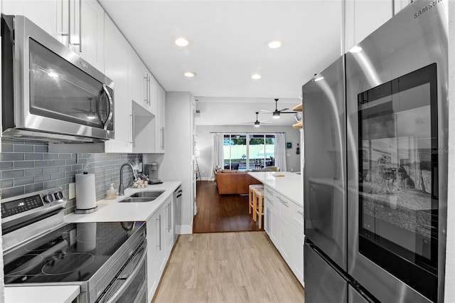 1322 N Bumby Ave, Orlando, FL 32803 - kitchen with stainless steel appliances, a ceiling fan, white cabinets, light countertops, and recessed lighting