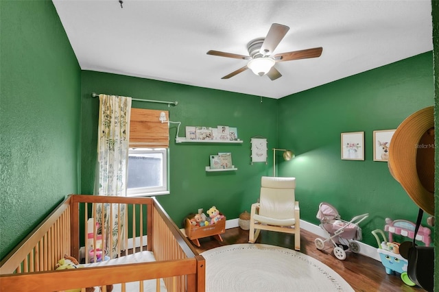 1322 N Bumby Ave, Orlando, FL 32803 - bedroom with wood finished floors, a crib, and ceiling fan