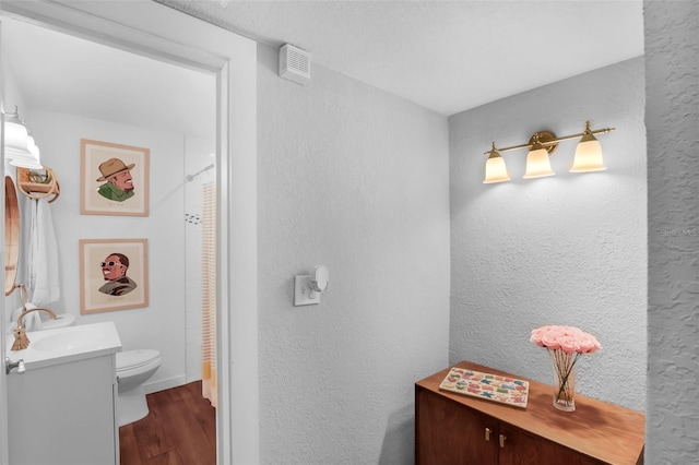1322 N Bumby Ave, Orlando, FL 32803 - full bathroom with vanity, wood finished floors, a textured wall, and a shower