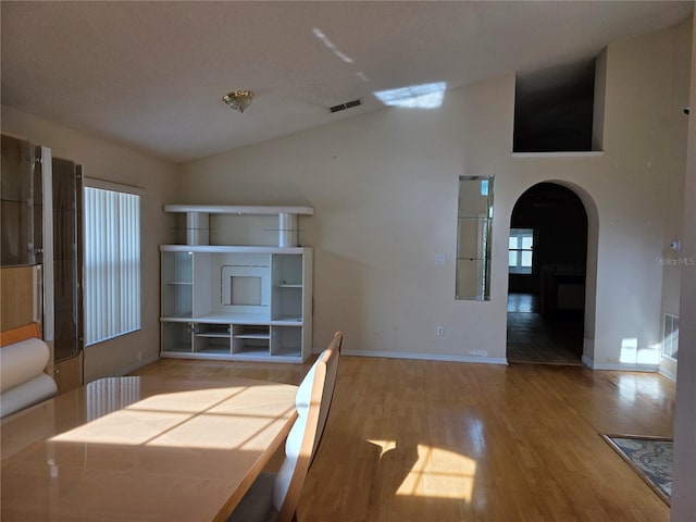 1797 Tillstream Dr, Orlando, FL 32818 - unfurnished dining area featuring arched walkways, lofted ceiling, and wood finished floors