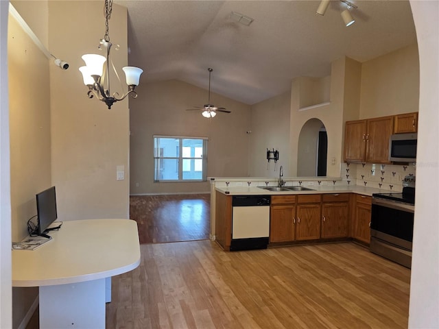 1797 Tillstream Dr, Orlando, FL 32818 - kitchen featuring stainless steel appliances, brown cabinetry, open floor plan, a ceiling fan, and vaulted ceiling