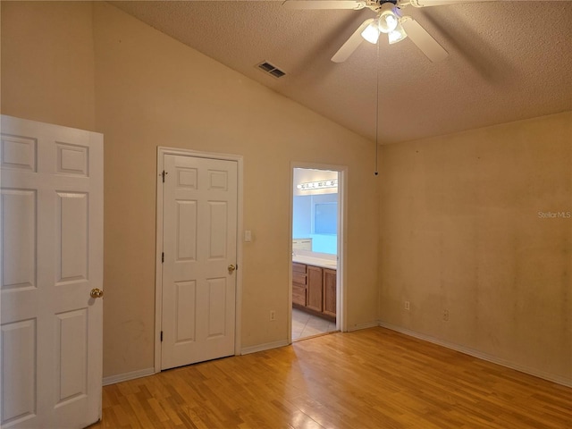 1797 Tillstream Dr, Orlando, FL 32818 - empty room featuring light wood-style flooring, a ceiling fan, vaulted ceiling, and a textured ceiling