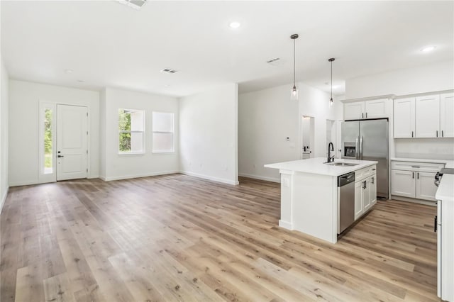 10599 N Umber Ter, Citrus Springs, FL 34434 - kitchen featuring appliances with stainless steel finishes, light countertops, open floor plan, light wood-style floors, and a kitchen island with sink