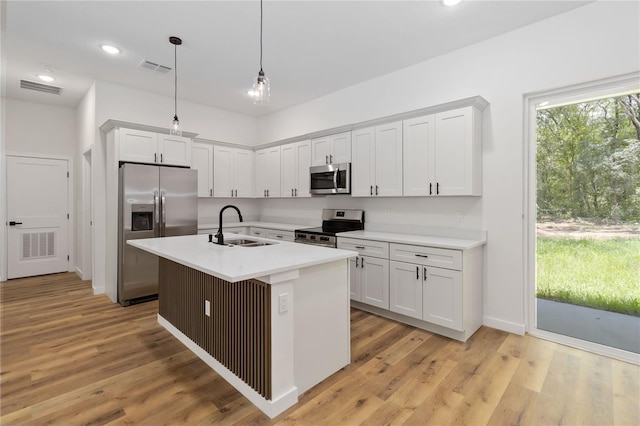 10611 N Umber Ter, Citrus Springs, FL 34434 - kitchen featuring appliances with stainless steel finishes, light countertops, white cabinetry, light wood-style floors, and pendant lighting