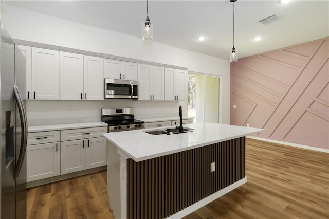 10611 N Umber Ter, Citrus Springs, FL 34434 - kitchen with stainless steel appliances, light wood finished floors, pendant lighting, light countertops, and a kitchen island with sink