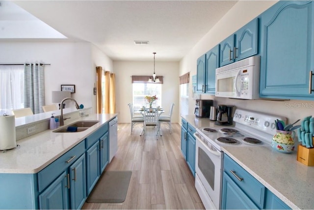 331 Bridgewater Dr, Davenport, FL 33897 - kitchen featuring white appliances, blue cabinets, light wood-style floors, hanging light fixtures, and a chandelier