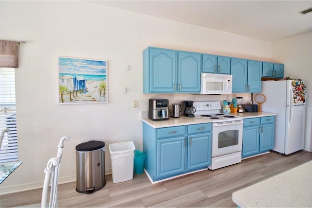 331 Bridgewater Dr, Davenport, FL 33897 - kitchen featuring white appliances, blue cabinetry, light wood-type flooring, and light countertops