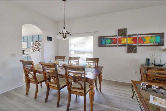 331 Bridgewater Dr, Davenport, FL 33897 - dining area featuring a chandelier, light wood finished floors, and arched walkways
