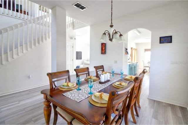 331 Bridgewater Dr, Davenport, FL 33897 - dining room featuring arched walkways, light wood-type flooring, and stairs
