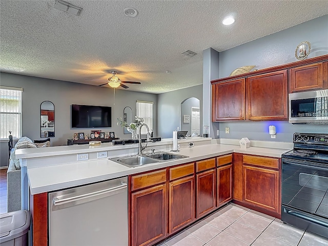 2530 The Oaks Blvd, Kissimmee, FL 34746 - kitchen featuring stainless steel appliances, open floor plan, a textured ceiling, a peninsula, and arched walkways