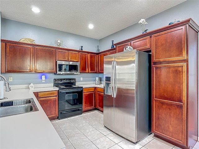 2530 The Oaks Blvd, Kissimmee, FL 34746 - kitchen with appliances with stainless steel finishes, a textured ceiling, light countertops, light tile patterned floors, and reddish brown cabinets