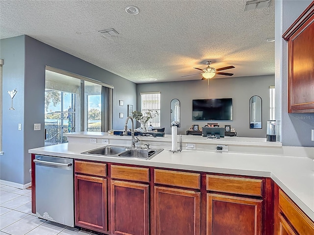 2530 The Oaks Blvd, Kissimmee, FL 34746 - kitchen featuring stainless steel dishwasher, open floor plan, light countertops, a ceiling fan, and a textured ceiling