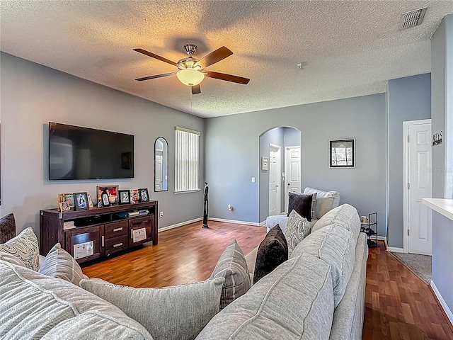 2530 The Oaks Blvd, Kissimmee, FL 34746 - living room featuring arched walkways, a ceiling fan, wood finished floors, and a textured ceiling