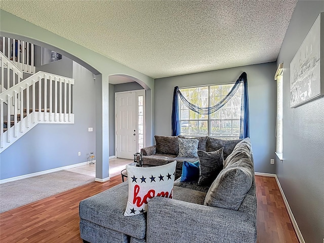 2530 The Oaks Blvd, Kissimmee, FL 34746 - living room with wood finished floors, a textured ceiling, stairs, and arched walkways
