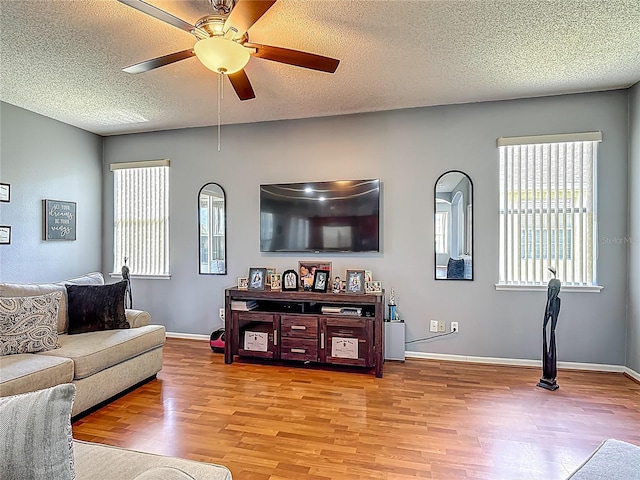 2530 The Oaks Blvd, Kissimmee, FL 34746 - living area featuring light wood-style floors, healthy amount of natural light, ceiling fan, and a textured ceiling