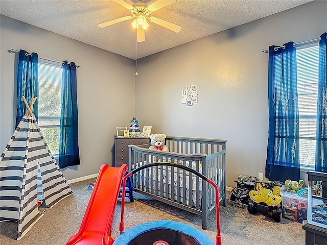 2530 The Oaks Blvd, Kissimmee, FL 34746 - bedroom featuring carpet floors, a textured ceiling, a ceiling fan, and a nursery area