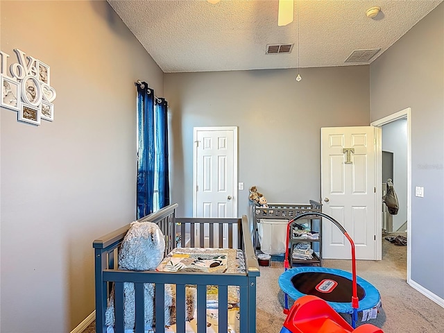 2530 The Oaks Blvd, Kissimmee, FL 34746 - carpeted bedroom featuring a textured ceiling, ceiling fan, and a nursery area