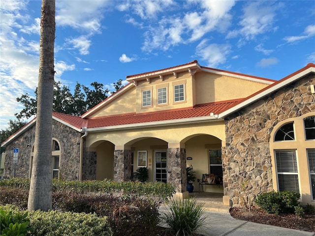 2770 Club Cortile Cir Unit A, Kissimmee, FL 34746 - view of front of house with stone siding, stucco siding, covered porch, and a tile roof