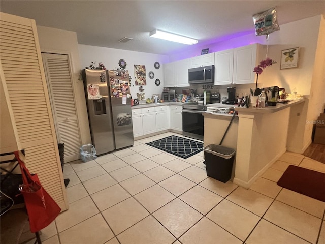 2770 Club Cortile Cir Unit A, Kissimmee, FL 34746 - kitchen with appliances with stainless steel finishes, light tile patterned floors, a peninsula, and white cabinets