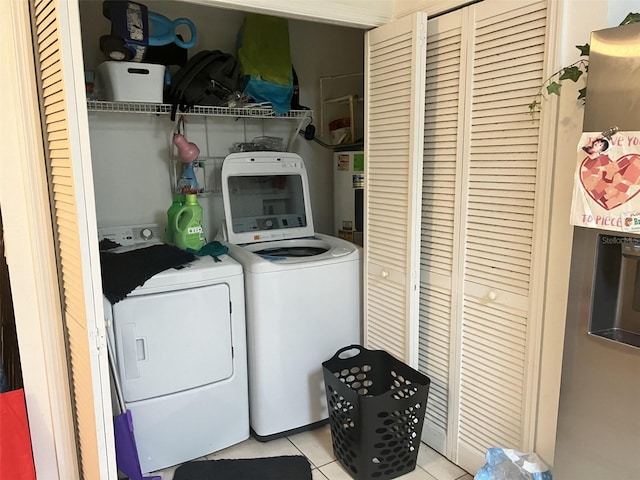 2770 Club Cortile Cir Unit A, Kissimmee, FL 34746 - laundry room with washing machine and clothes dryer, electric water heater, and light tile patterned floors