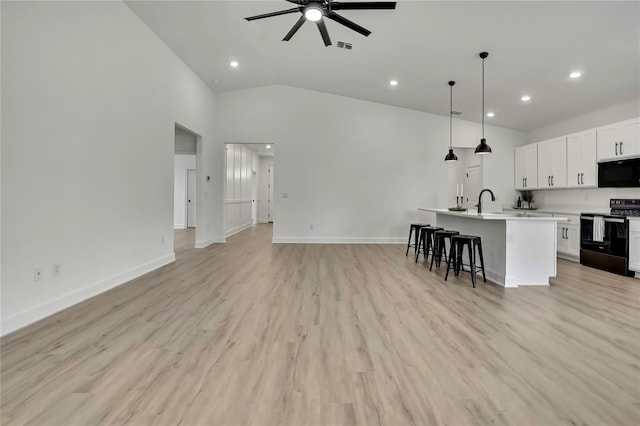 9739 Loretto St, Spring Hill, FL 34608 - kitchen with black microwave, electric range oven, open floor plan, ceiling fan, and recessed lighting