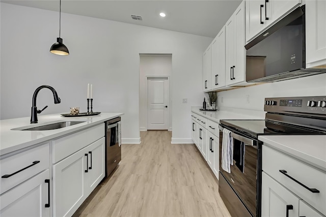 9739 Loretto St, Spring Hill, FL 34608 - kitchen featuring electric range, black microwave, dishwasher, light wood-style flooring, and light countertops