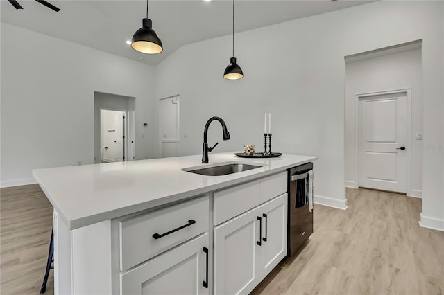 9739 Loretto St, Spring Hill, FL 34608 - kitchen featuring dishwashing machine, light wood finished floors, a center island with sink, decorative light fixtures, and white cabinets