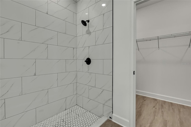 9739 Loretto St, Spring Hill, FL 34608 - bathroom with a tile shower, wood finished floors, and a walk in closet