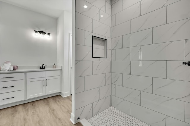 9739 Loretto St, Spring Hill, FL 34608 - bathroom featuring tiled shower, vanity, and wood finished floors