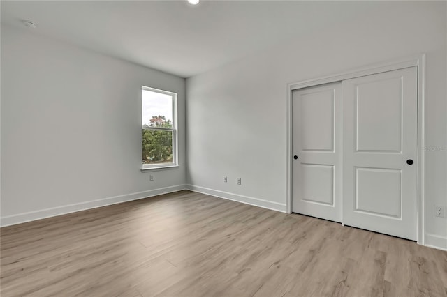 9739 Loretto St, Spring Hill, FL 34608 - unfurnished bedroom featuring light wood-style flooring and a closet