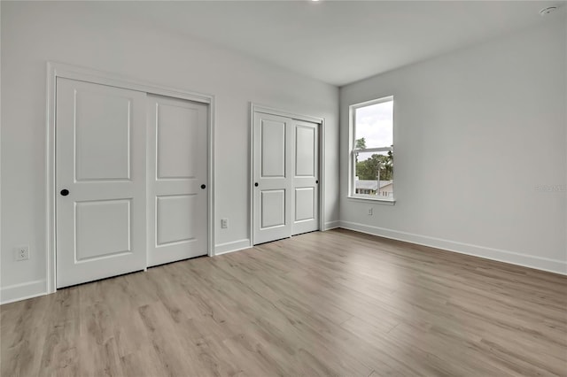 9739 Loretto St, Spring Hill, FL 34608 - unfurnished bedroom with multiple closets and light wood finished floors
