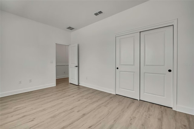 9739 Loretto St, Spring Hill, FL 34608 - unfurnished bedroom with light wood finished floors and a closet