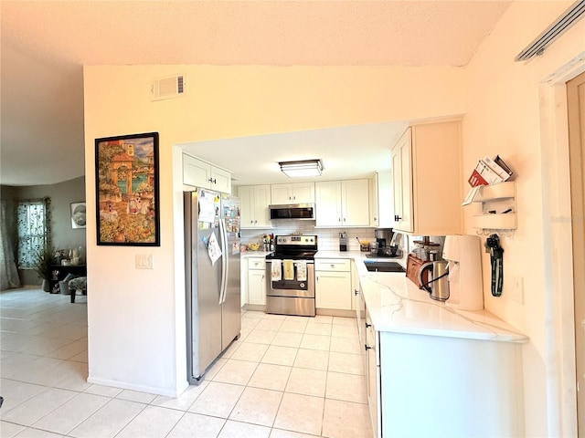 11310 Darlington Dr, Orlando, FL 32837 - kitchen with appliances with stainless steel finishes, light tile patterned flooring, light stone countertops, tasteful backsplash, and white cabinets