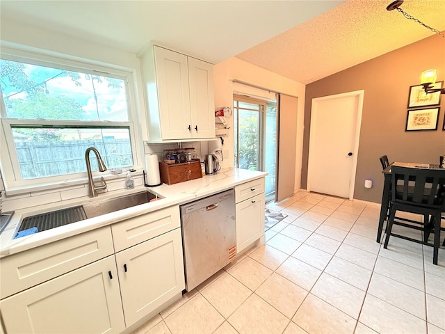 11310 Darlington Dr, Orlando, FL 32837 - kitchen with stainless steel dishwasher, light countertops, white cabinetry, light tile patterned floors, and vaulted ceiling