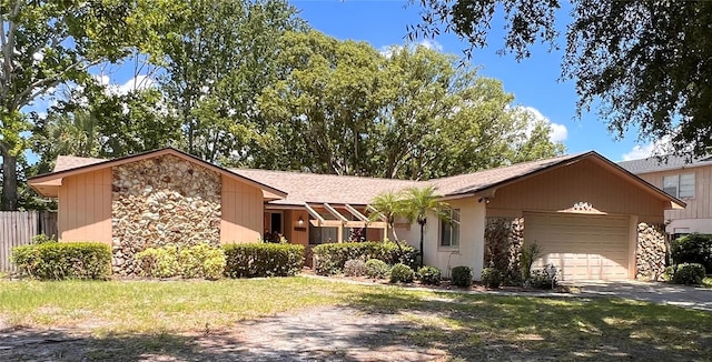 8547 Cedar Cove Dr, Orlando, FL 32819 - view of front of house featuring stone siding, concrete driveway, an attached garage, and a shingled roof