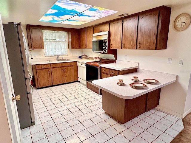 8547 Cedar Cove Dr, Orlando, FL 32819 - kitchen with appliances with stainless steel finishes, a peninsula, light countertops, and light tile patterned floors