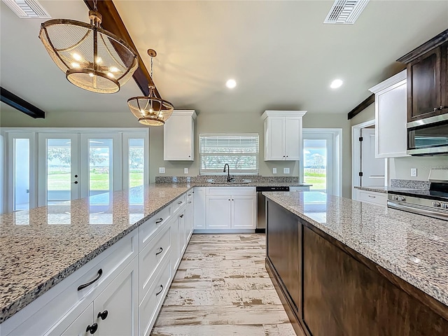 14243 County Road 450, Umatilla, FL 32784 - kitchen with stainless steel appliances, light stone countertops, white cabinetry, hanging light fixtures, and recessed lighting